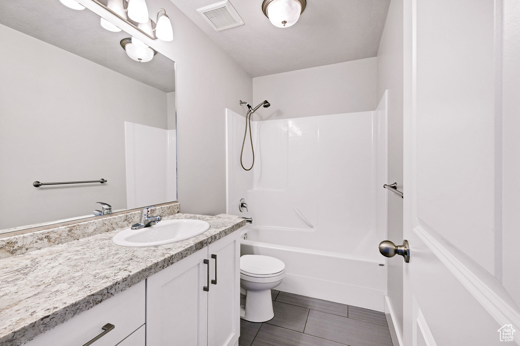 Bathroom featuring vanity, toilet, washtub / shower combination, and tile patterned flooring