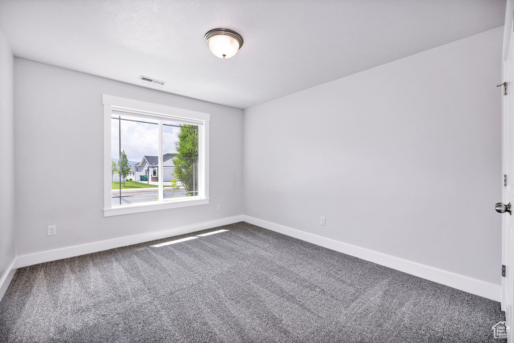 Carpeted empty room featuring baseboards