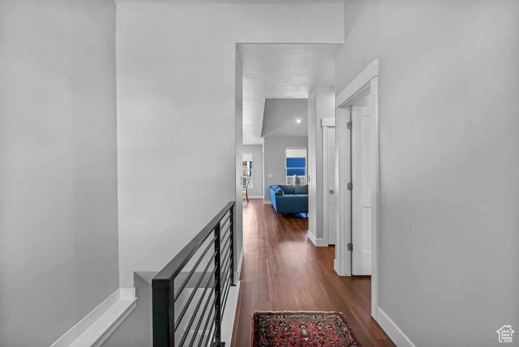 Corridor featuring dark wood finished floors and baseboards