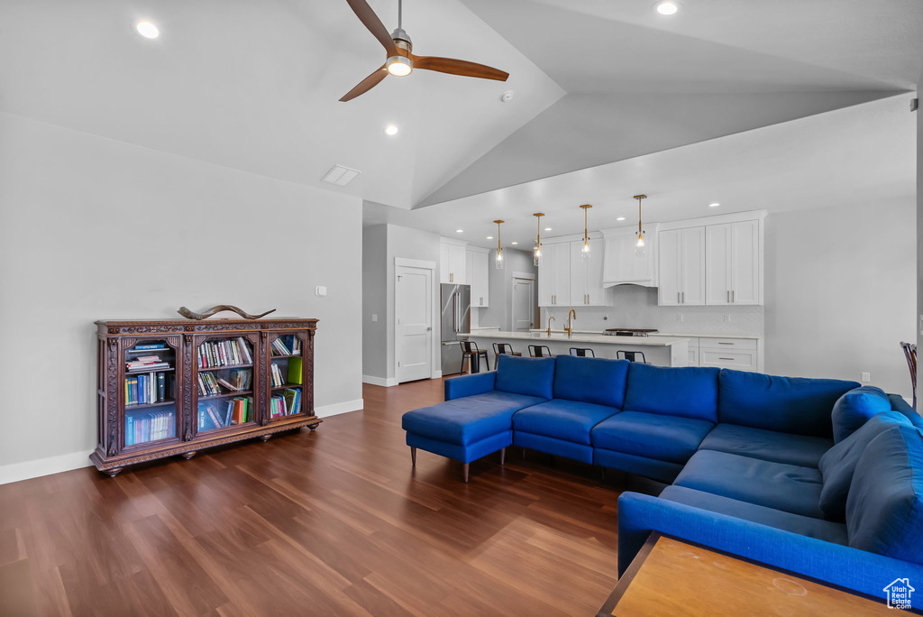 Living room featuring ceiling fan, dark wood-style flooring, baseboards, high vaulted ceiling, and recessed lighting