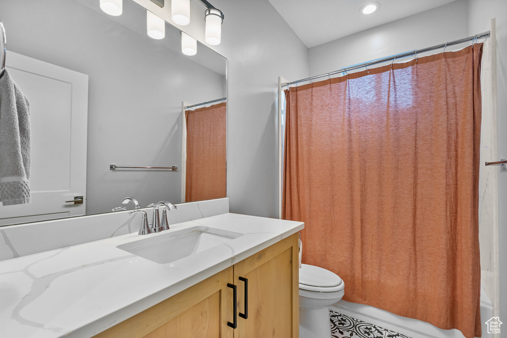 Full bath featuring toilet, vanity, and tile patterned flooring