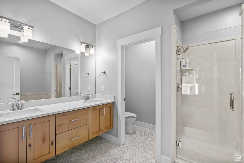 Full bath with a shower stall, toilet, and double vanity