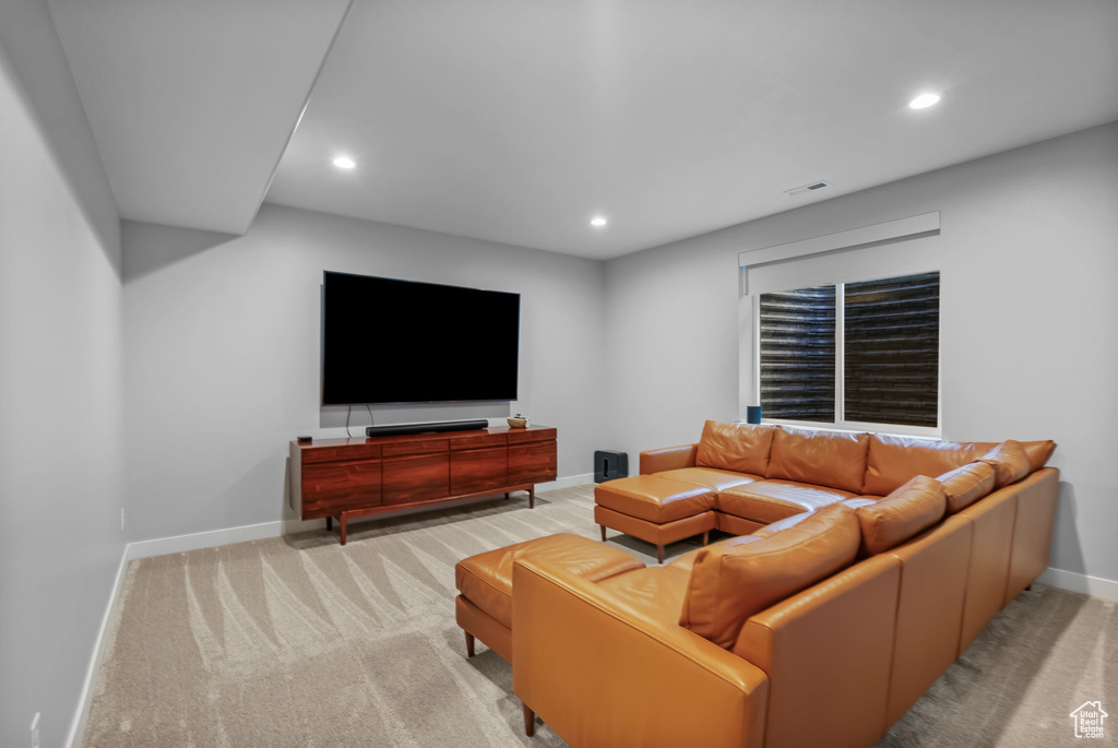 Living area with baseboards, recessed lighting, and light carpet