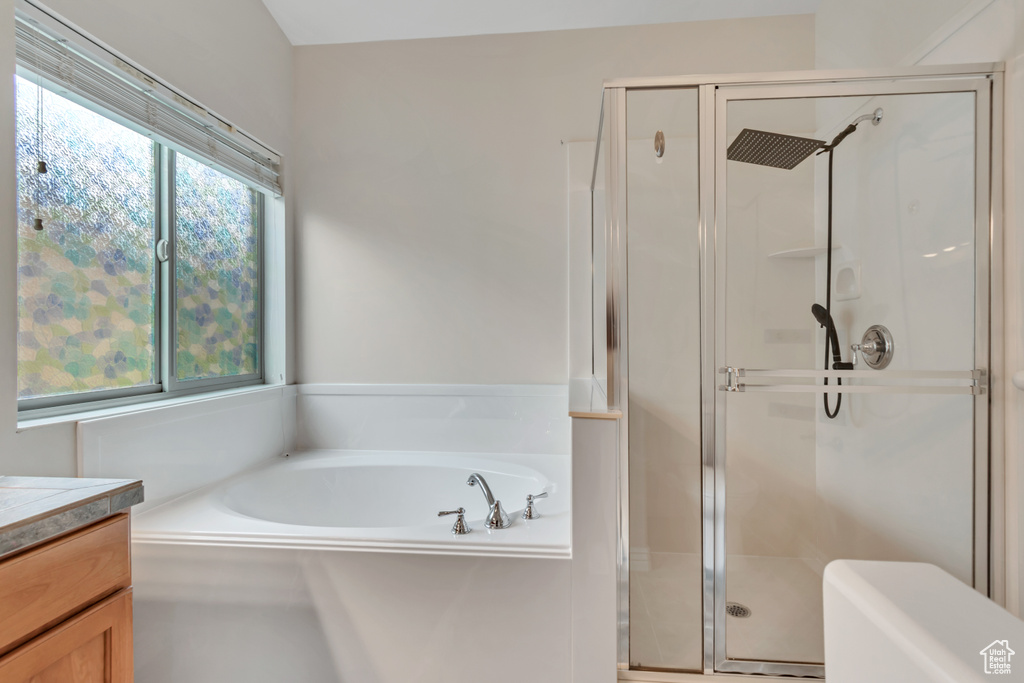 Bathroom featuring vanity, a stall shower, and a bath