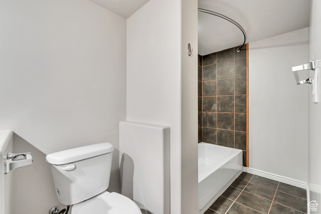 Bathroom with tile patterned floors, toilet, baseboards, and shower / bath combination