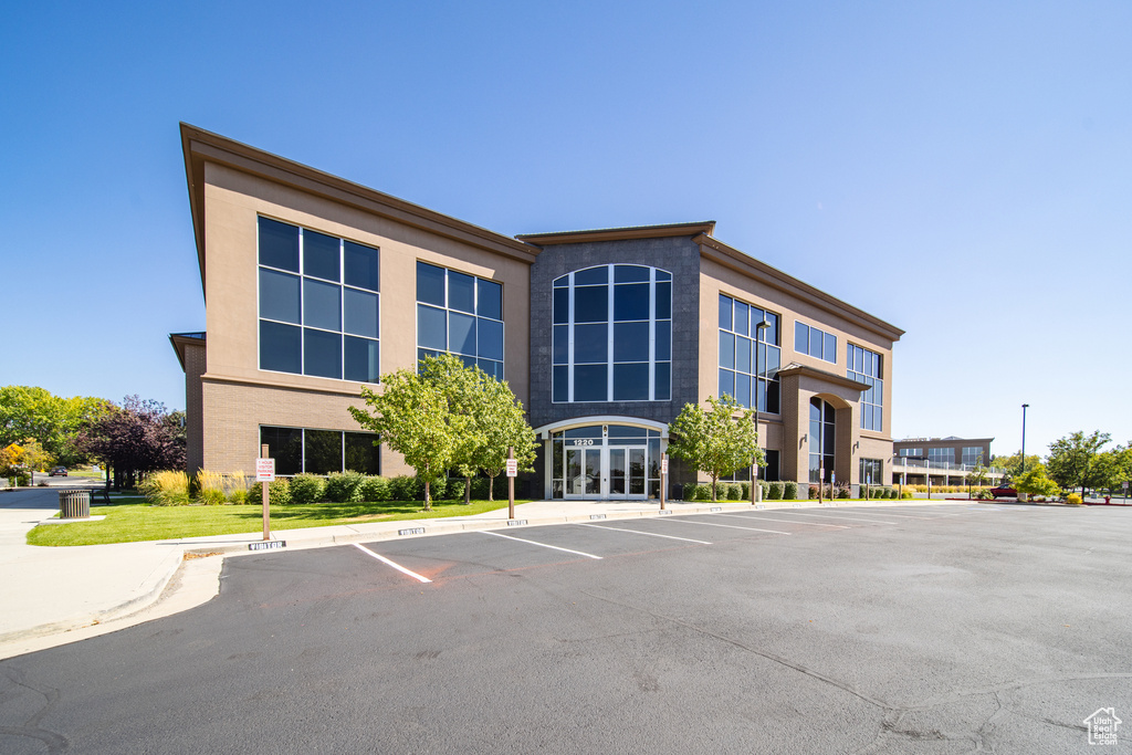 View of building exterior featuring uncovered parking