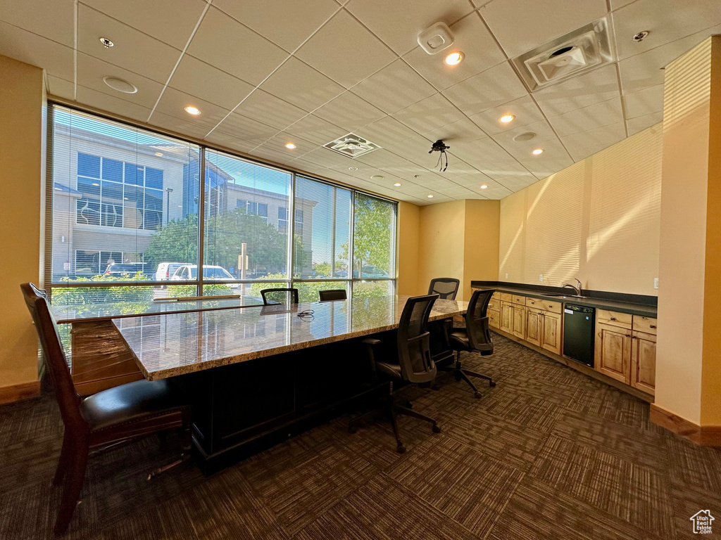 Office space with dark carpet, baseboards, a sink, and recessed lighting