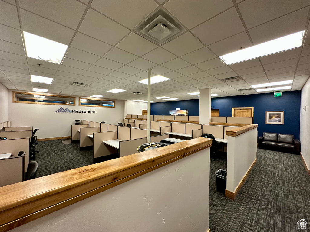 Misc room with dark carpet, baseboards, and a paneled ceiling