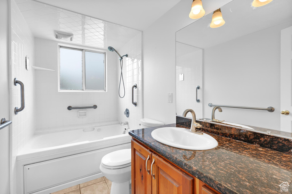 Bathroom featuring toilet, vanity, tile patterned flooring, and shower / tub combination