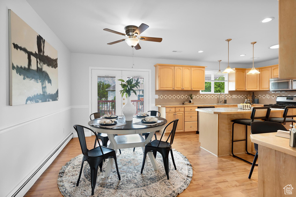Dining room with a baseboard radiator, light wood-style floors, a ceiling fan, and recessed lighting
