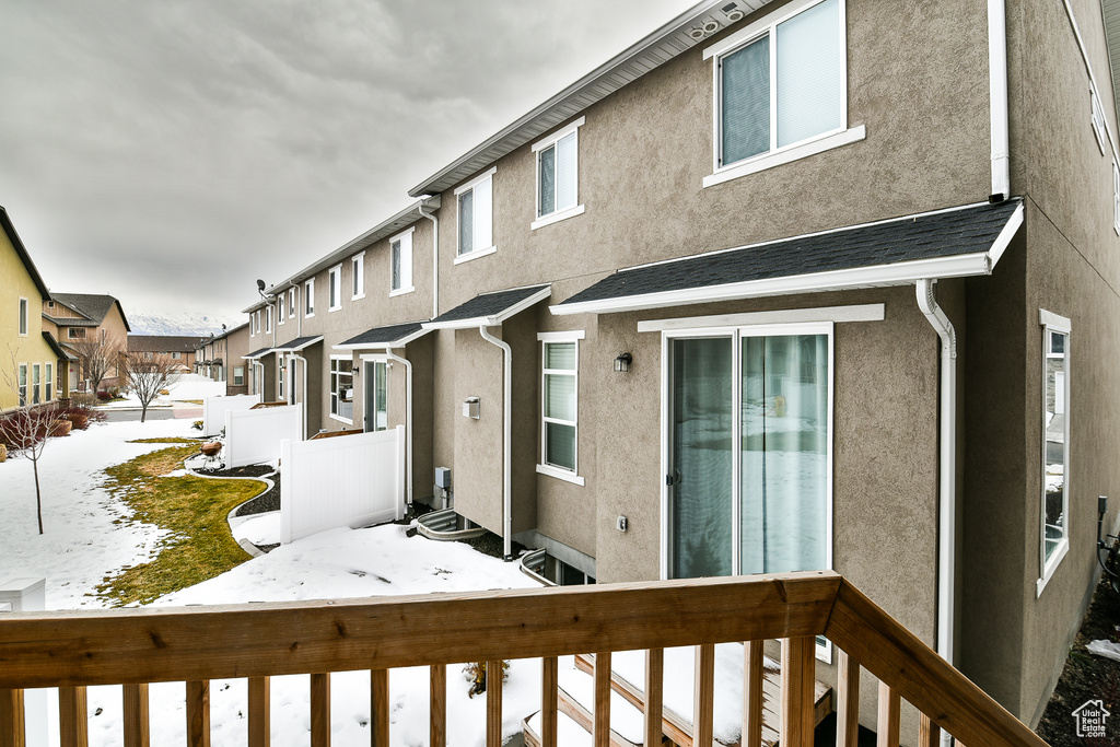 Snow covered property featuring stucco siding