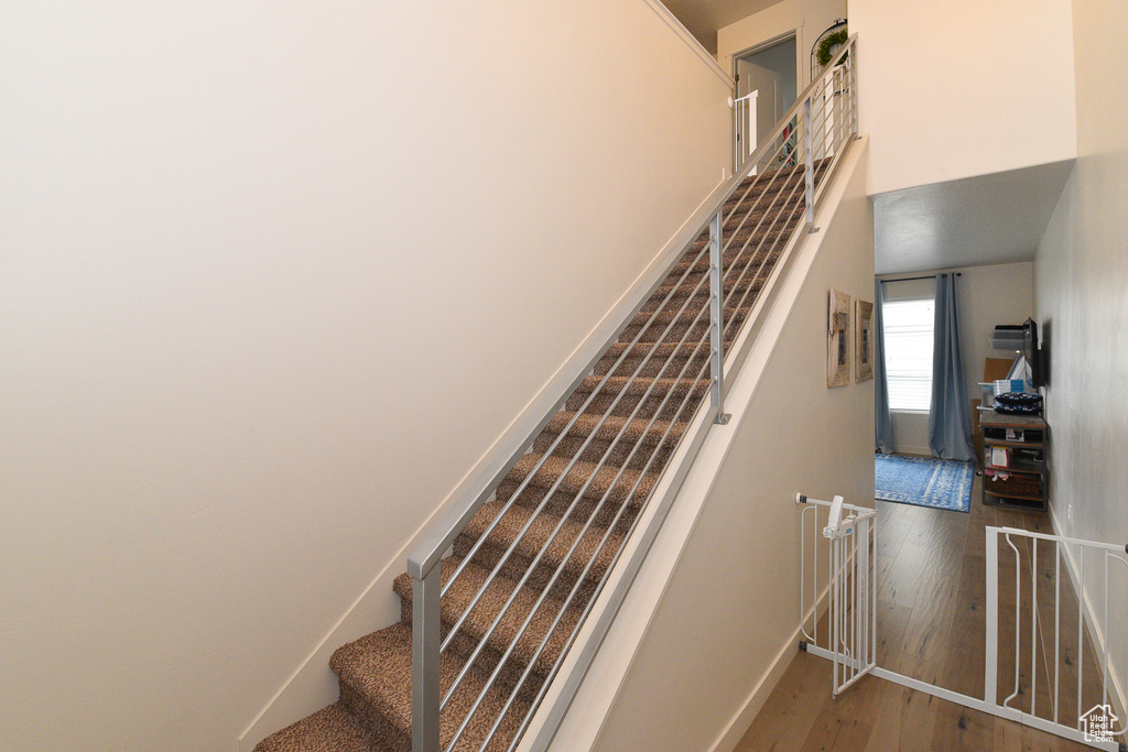 Stairway featuring wood finished floors and baseboards