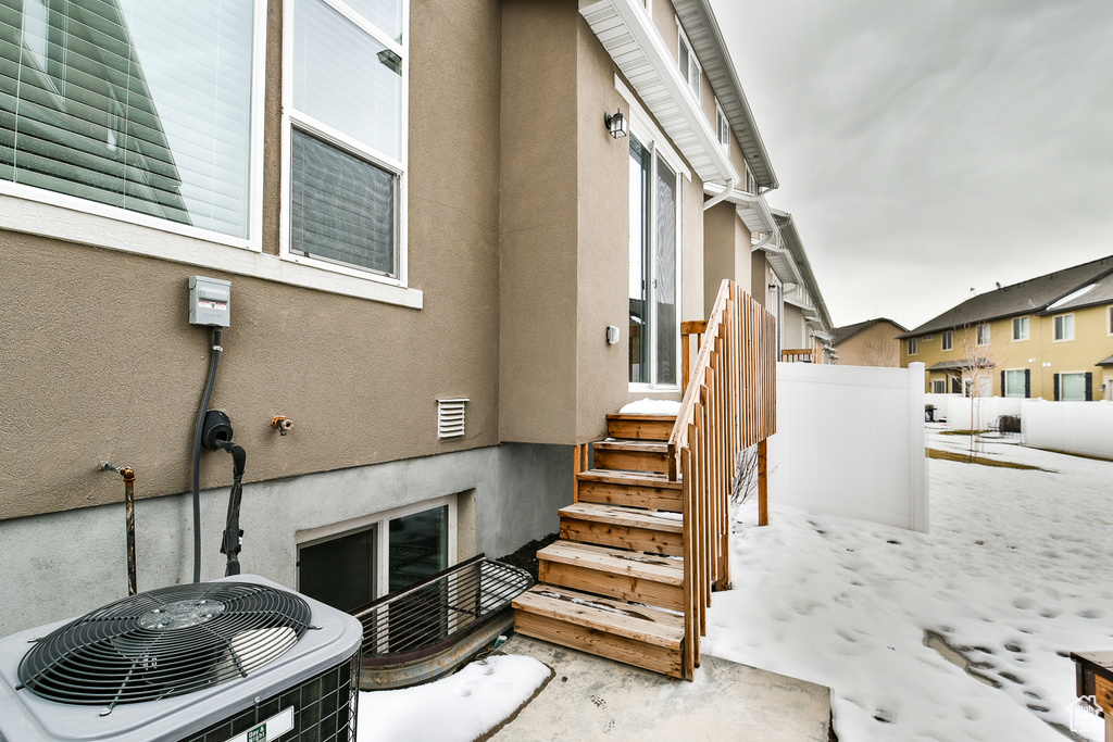 Exterior space with cooling unit and stucco siding