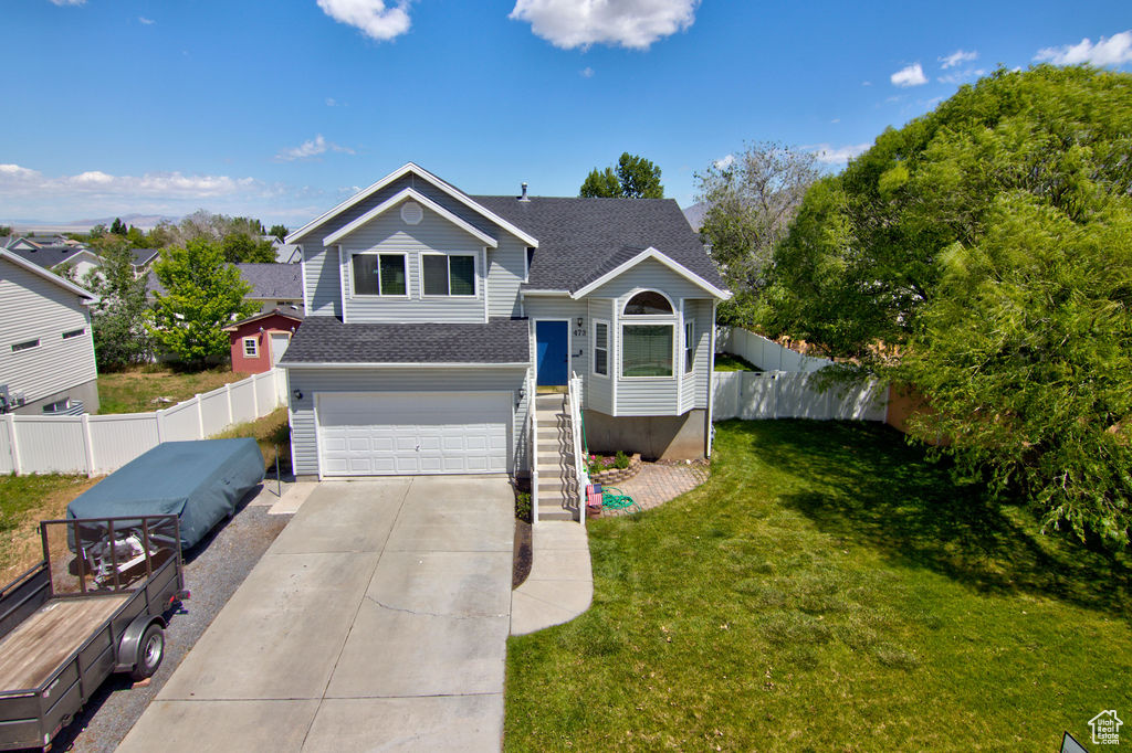 View of front of home featuring a garage, a shingled roof, and driveway