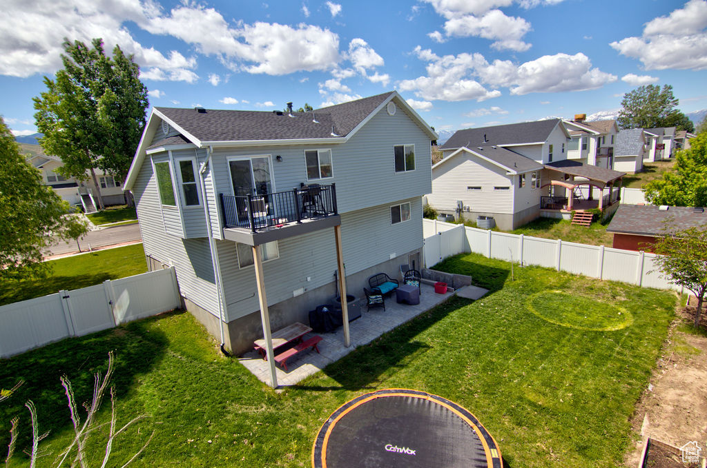 Rear view of house featuring a residential view, a patio area, an outdoor living space, roof with shingles, and a gate