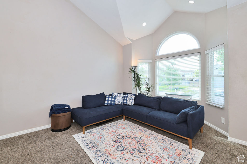 Living room with carpet, high vaulted ceiling, baseboards, and recessed lighting