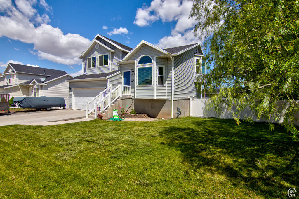 View of front of home featuring oil tank, driveway, and a garage