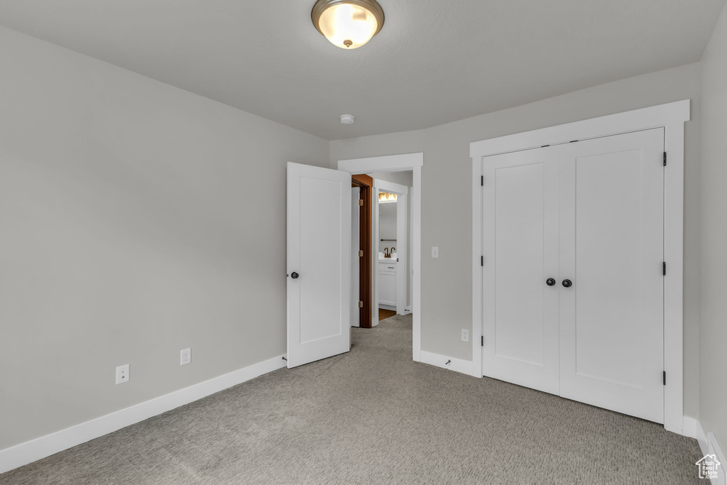 Unfurnished bedroom featuring carpet, baseboards, and a closet