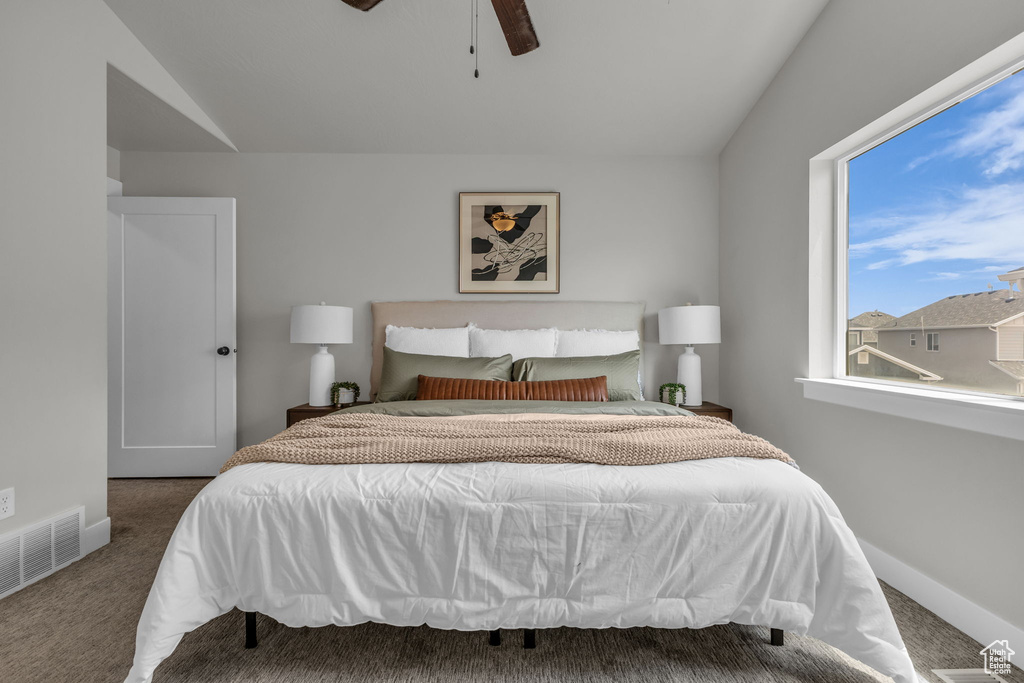 Bedroom featuring carpet floors, lofted ceiling, baseboards, and a ceiling fan