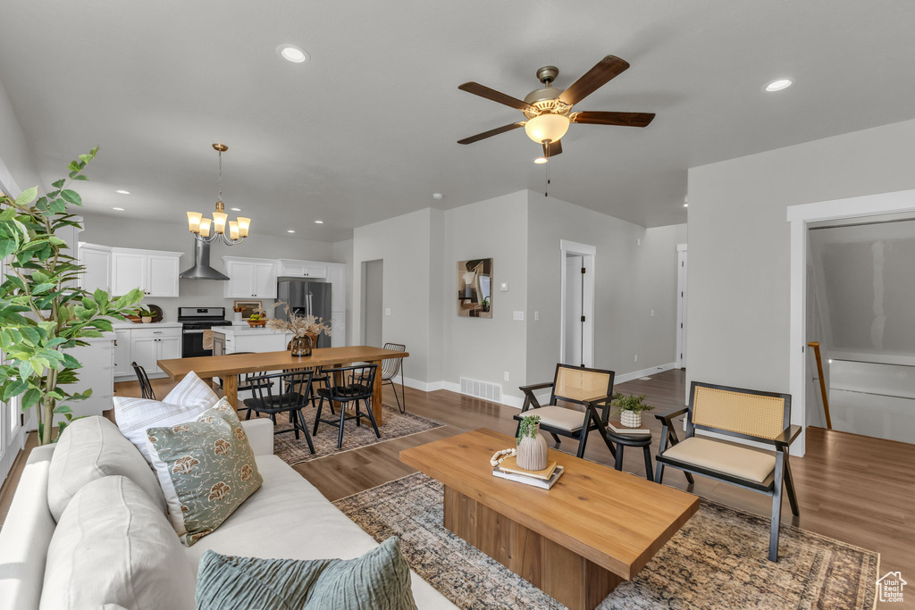 Living area featuring a ceiling fan, wood finished floors, recessed lighting, a chandelier, and baseboards