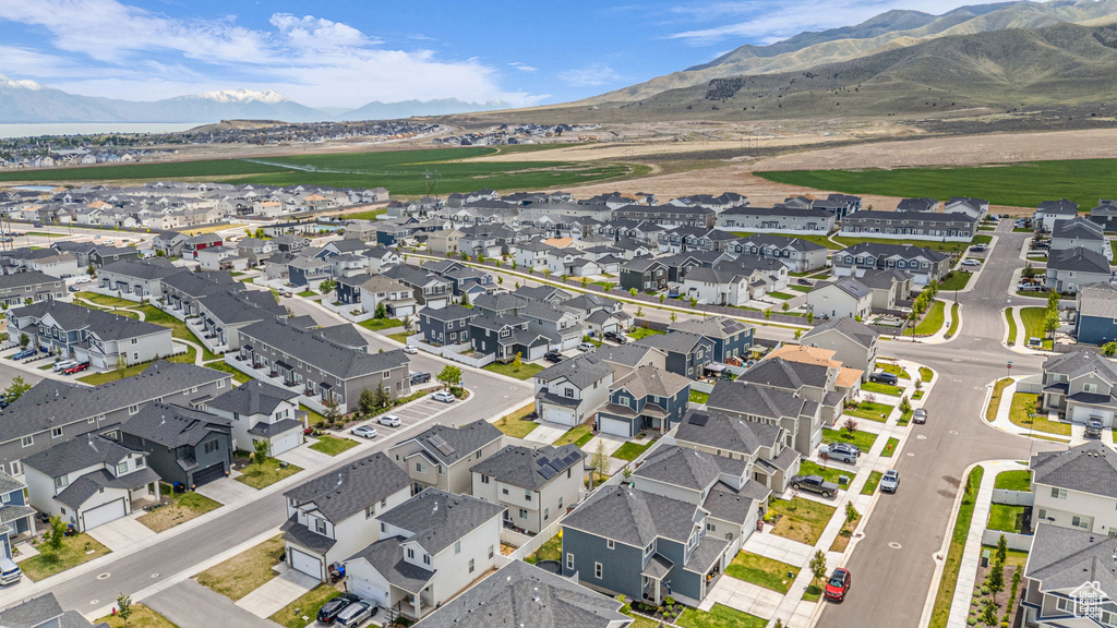 Aerial view of property and surrounding area featuring a mountainous background and nearby suburban area