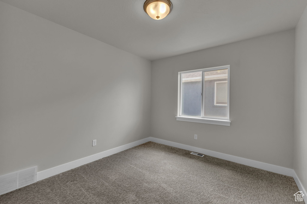 Spare room with baseboards and carpet