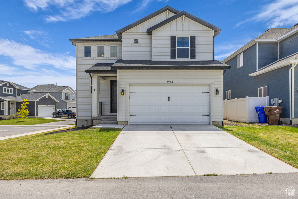 View of front of home with board and batten siding, concrete driveway, a garage, and a residential view
