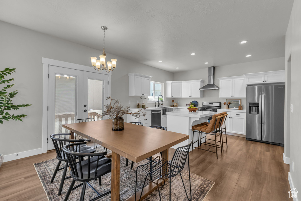 Dining room featuring light wood-type flooring, recessed lighting, baseboards, and a chandelier