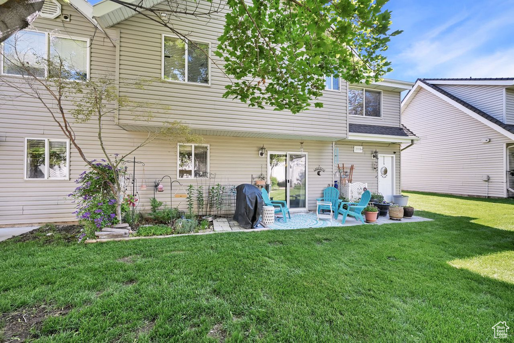 Rear view of property featuring a patio and a lawn
