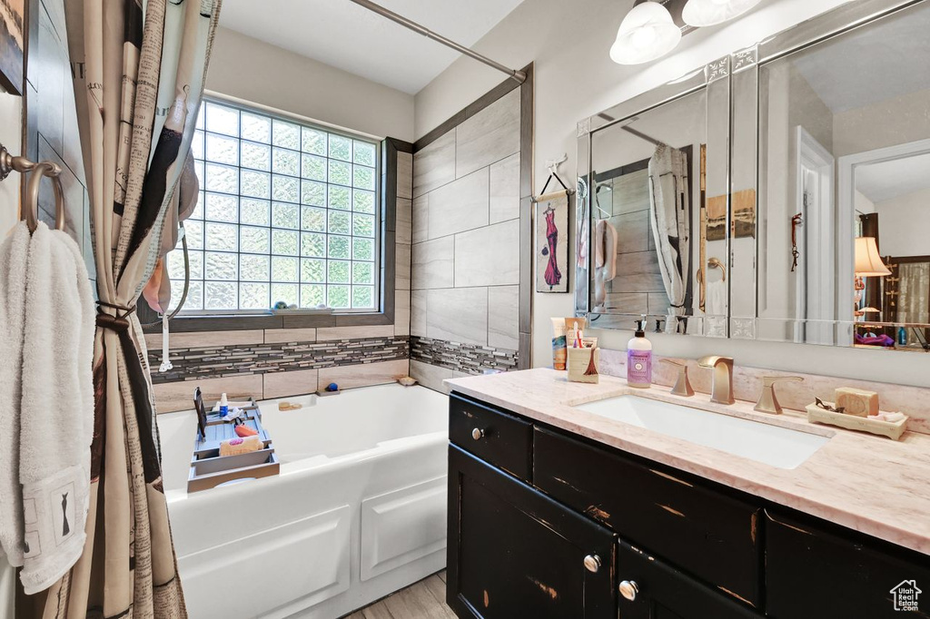 Full bathroom with a garden tub and vanity