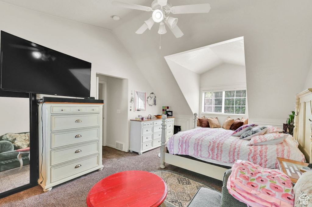Carpeted bedroom with vaulted ceiling and a ceiling fan