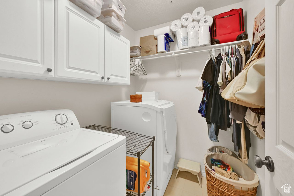 Washroom featuring washing machine and clothes dryer and cabinet space