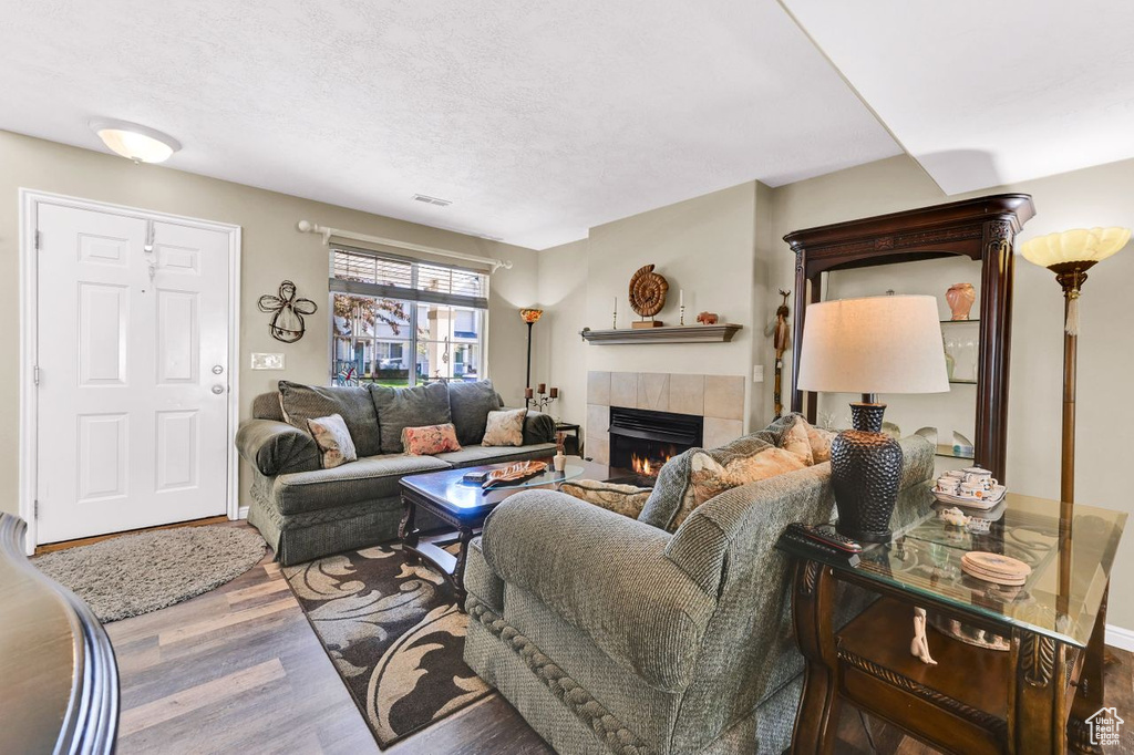 Living area featuring a tile fireplace and wood finished floors