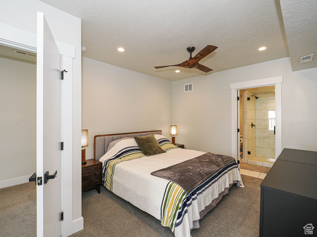 Bedroom with recessed lighting, dark carpet, ceiling fan, ensuite bath, and a textured ceiling