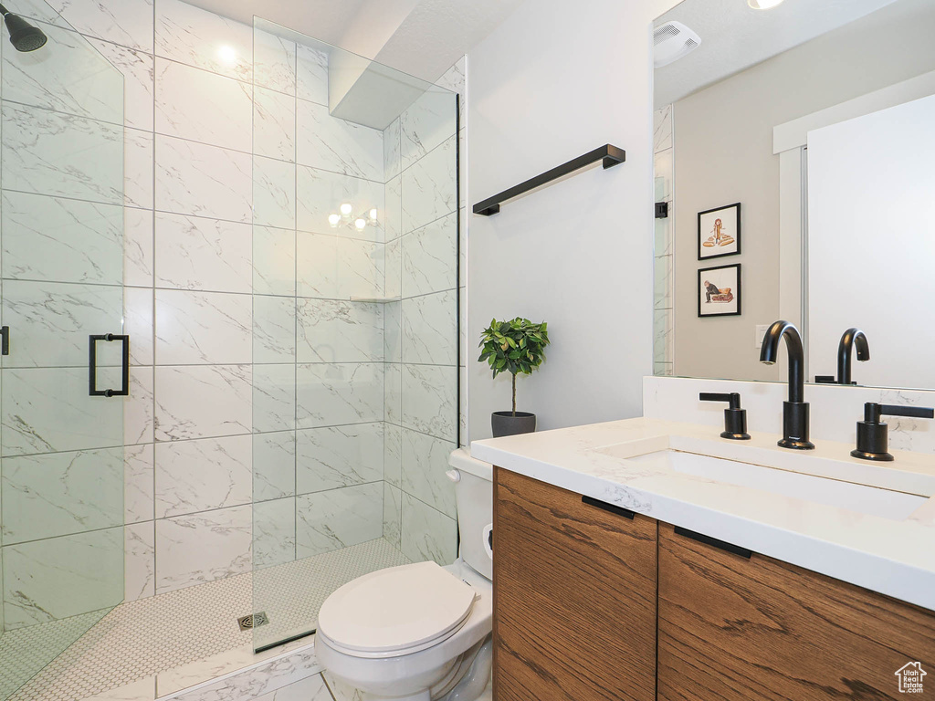 Full bath with a shower stall, toilet, and vanity