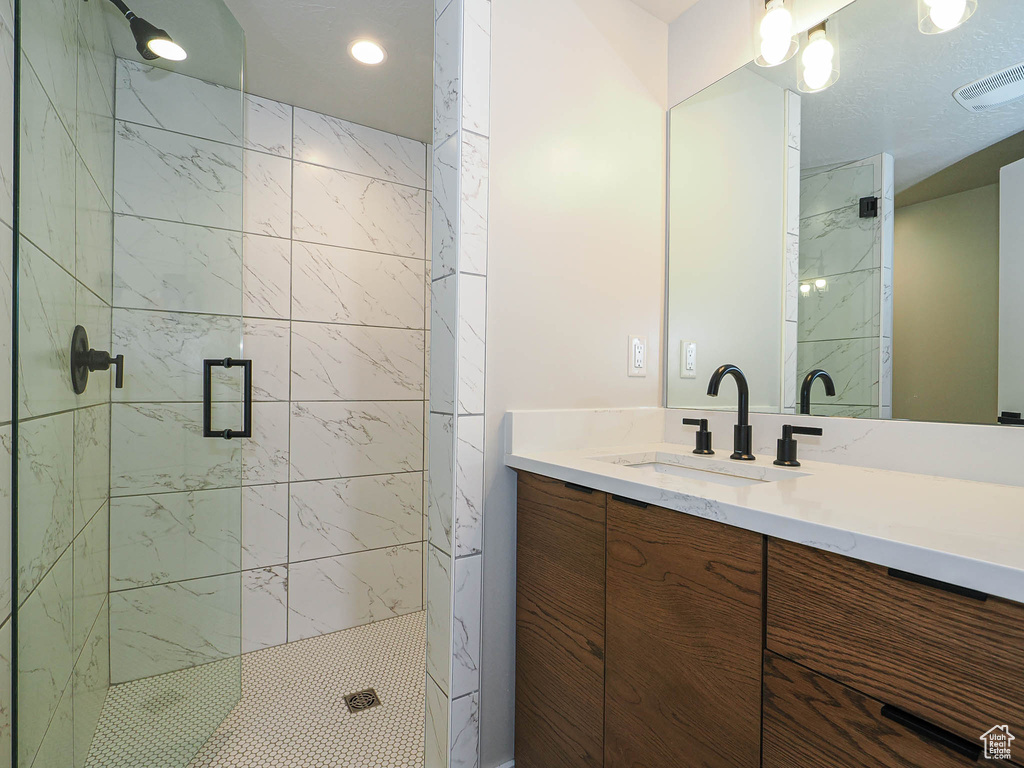 Full bathroom with a shower stall, vanity, and recessed lighting