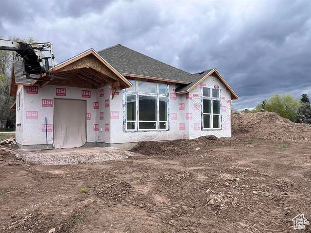 Rear view of property with roof with shingles