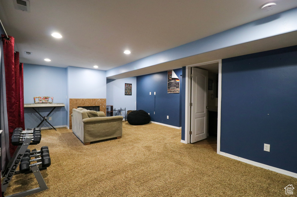 Carpeted living area featuring baseboards, a fireplace, and recessed lighting