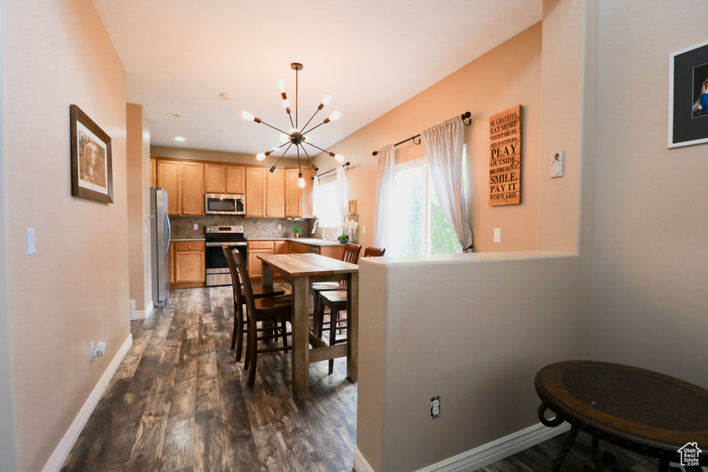 Dining space with a chandelier, dark wood-style flooring, baseboards, and recessed lighting