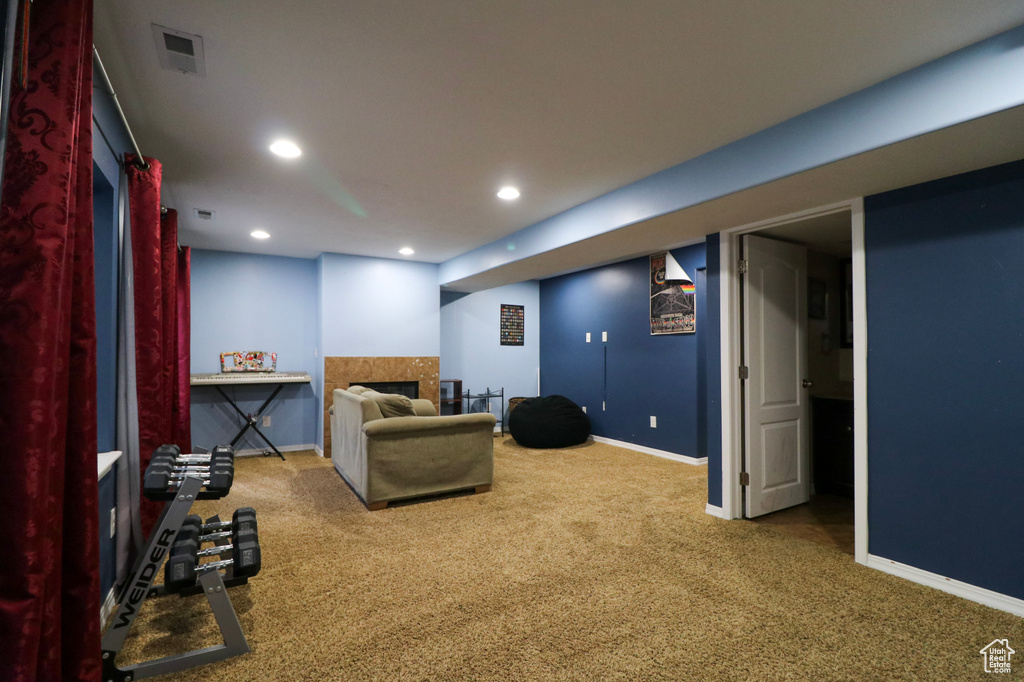 Carpeted living room with baseboards, recessed lighting, and a fireplace