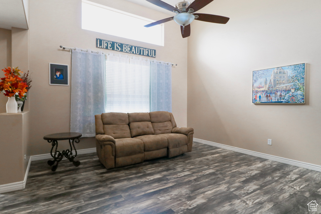 Living area with ceiling fan, wood finished floors, and baseboards