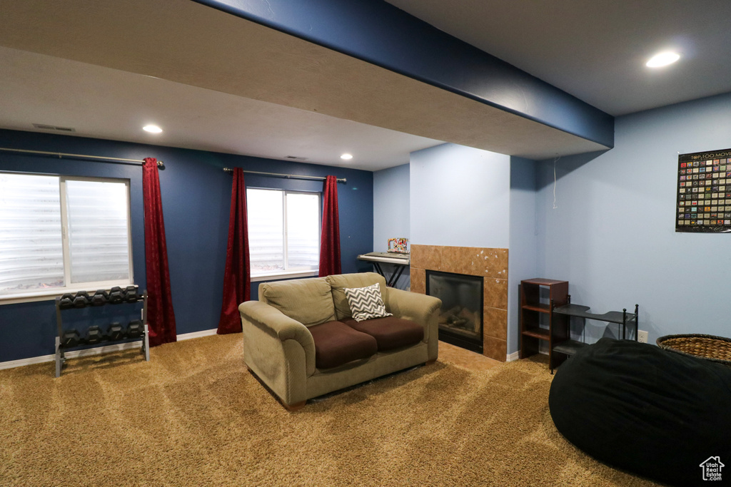 Living area featuring carpet, a tile fireplace, baseboards, and recessed lighting