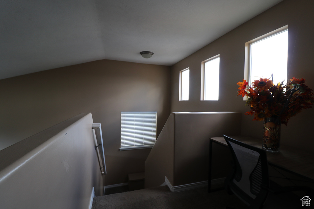 Staircase featuring vaulted ceiling and baseboards