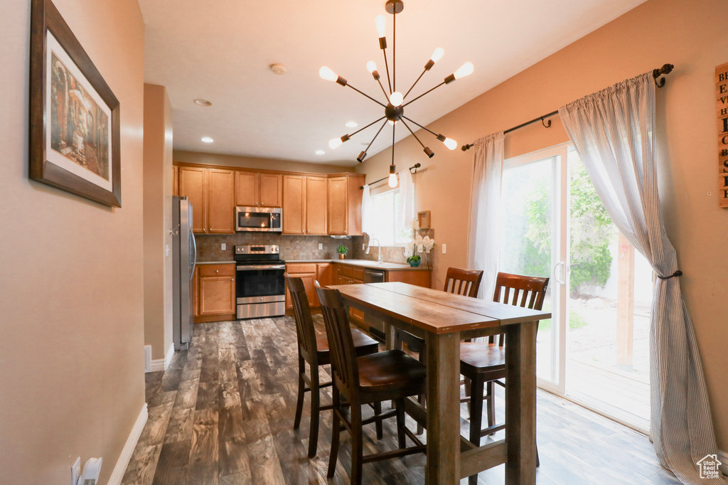 Dining space featuring a chandelier, dark wood-style floors, recessed lighting, and baseboards