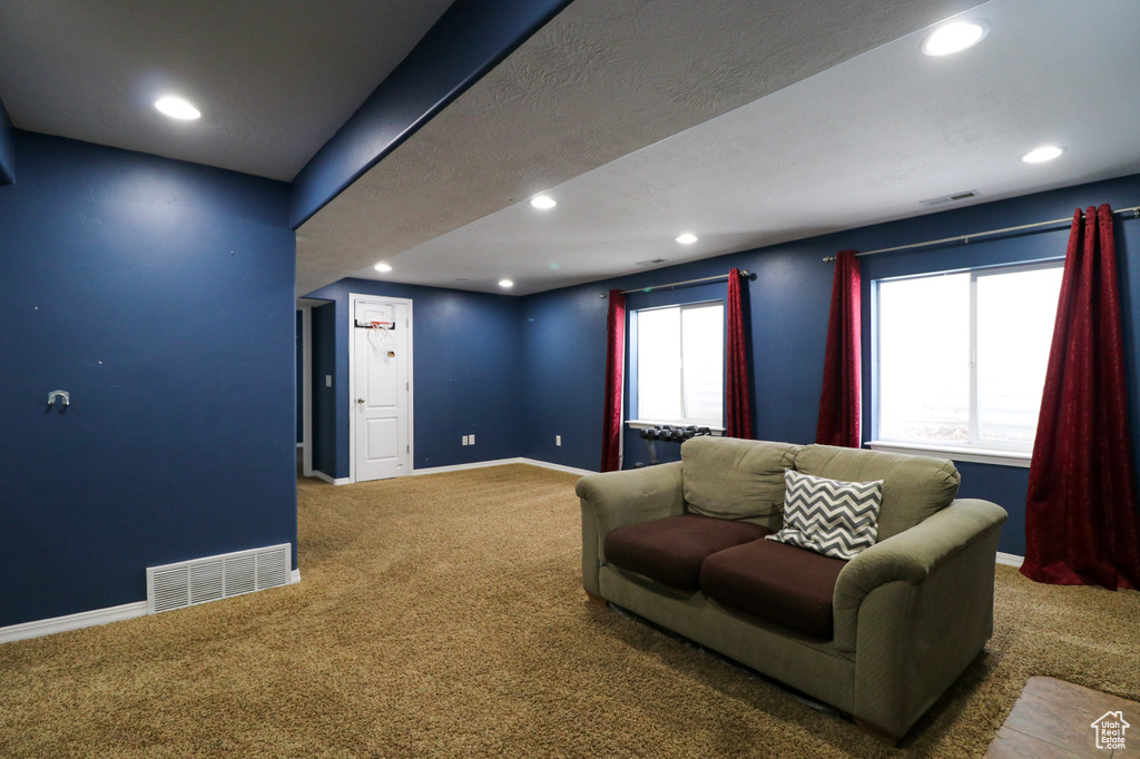 Carpeted living area with recessed lighting and baseboards