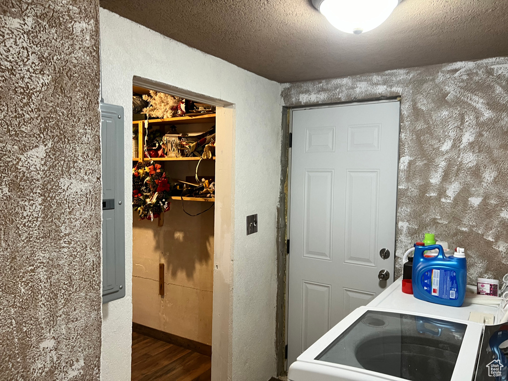 Washroom featuring wood finished floors, a textured ceiling, baseboards, and a textured wall