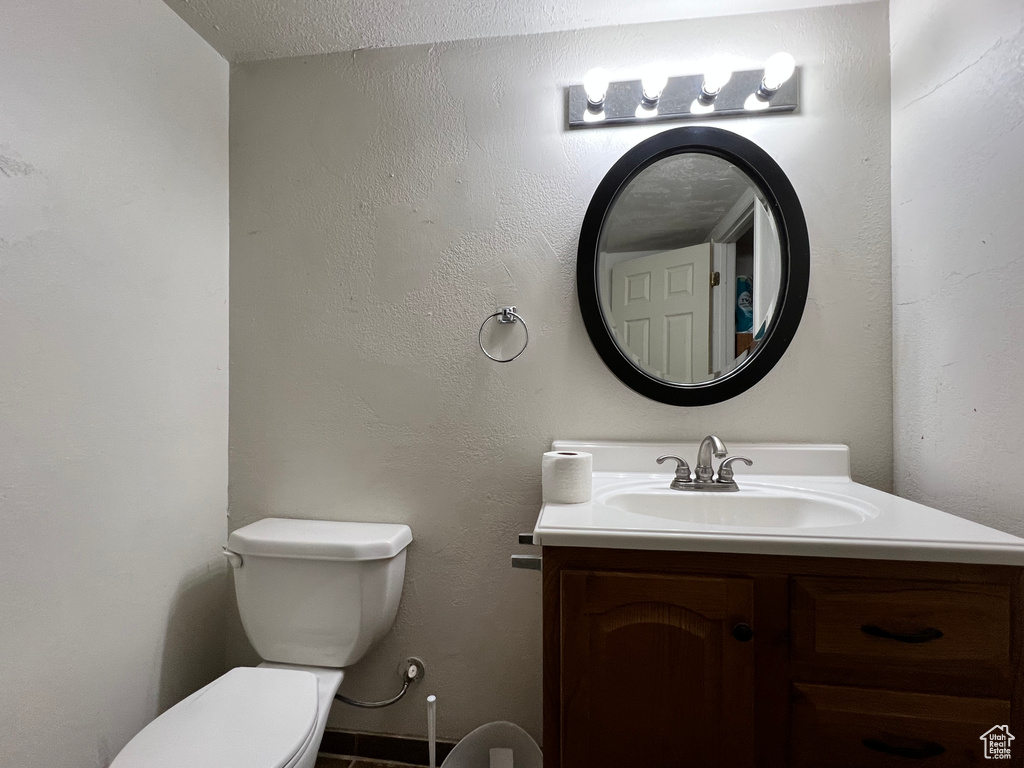 Half bathroom with toilet and vanity