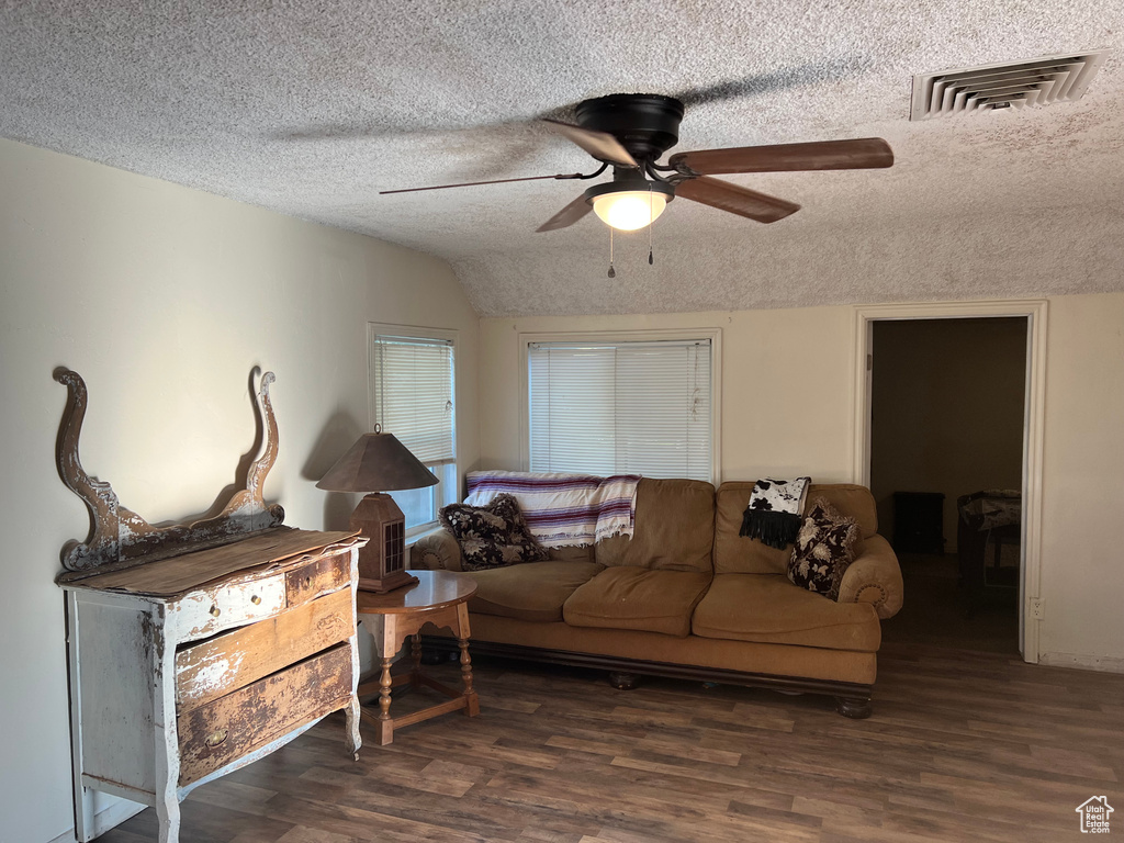 Living area featuring ceiling fan, a textured ceiling, and wood finished floors