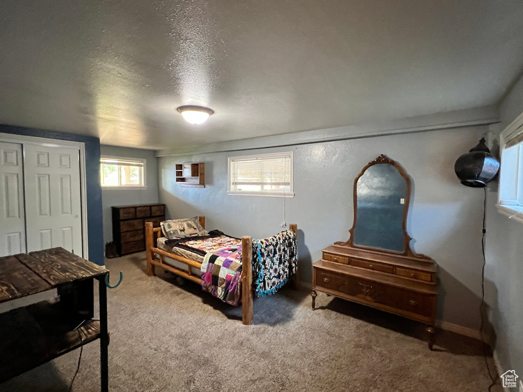 Bedroom with carpet, a textured ceiling, and a closet