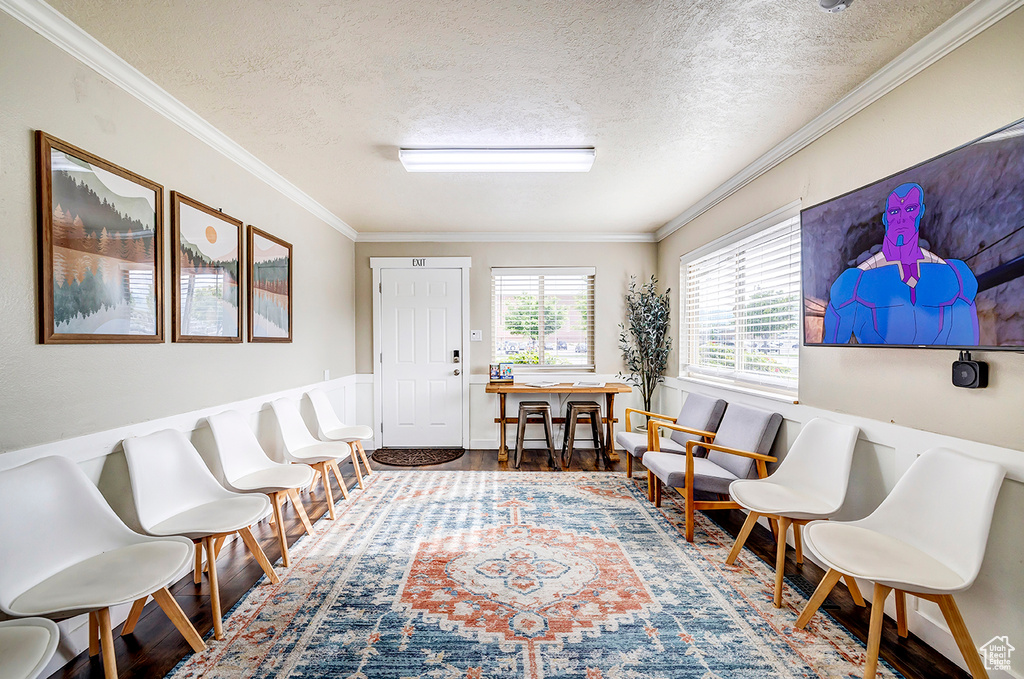 Sitting room featuring a textured ceiling, wood finished floors, and crown molding